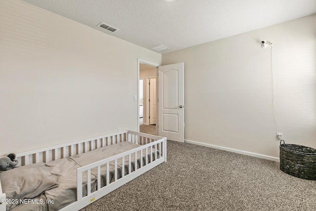 bedroom with carpet floors and a textured ceiling