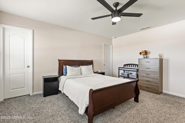 bedroom with ceiling fan, carpet floors, and a textured ceiling