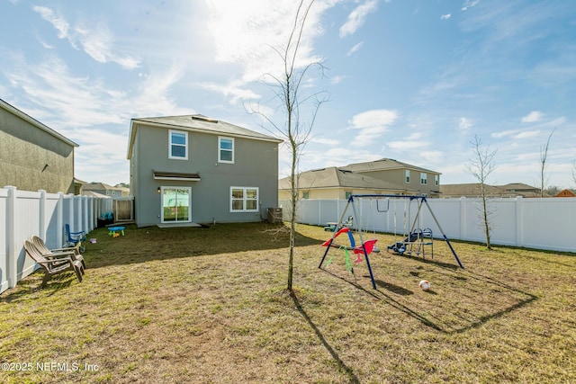 back of house featuring a playground and a yard