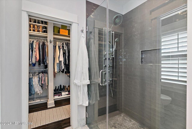 full bathroom with toilet, a stall shower, and a spacious closet