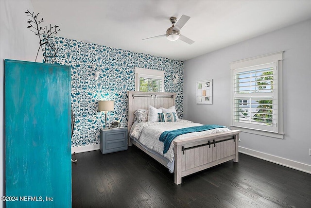 bedroom with dark wood-type flooring, multiple windows, and baseboards