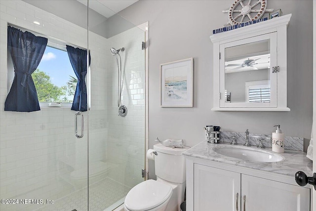 bathroom with toilet, a shower stall, a wealth of natural light, and vanity