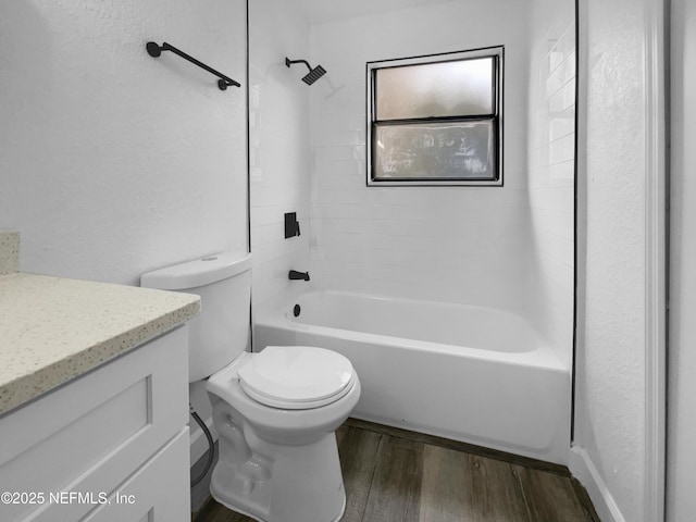 full bathroom with hardwood / wood-style flooring, vanity, tiled shower / bath, and toilet