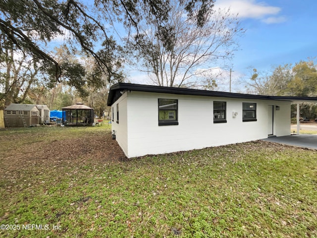 exterior space featuring a gazebo, a lawn, and a carport