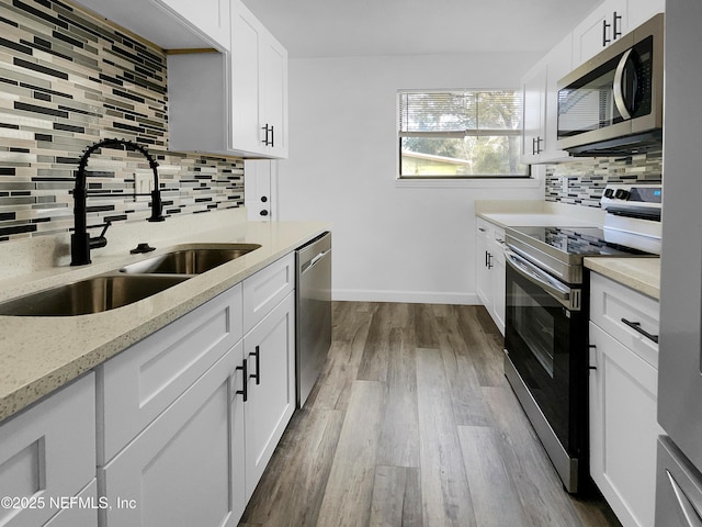 kitchen featuring sink, wood-type flooring, white cabinets, and appliances with stainless steel finishes