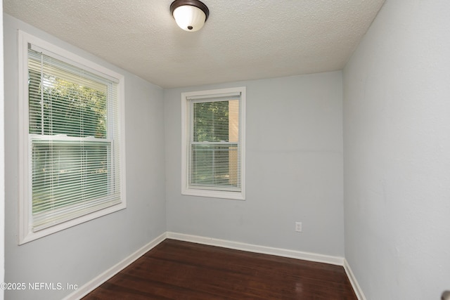 unfurnished room with dark hardwood / wood-style floors and a textured ceiling