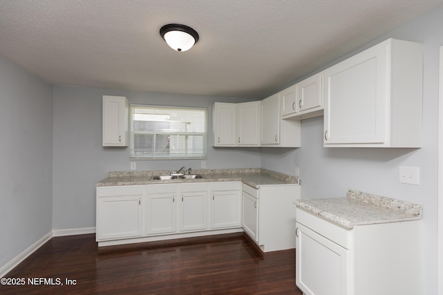 kitchen with sink, a textured ceiling, dark hardwood / wood-style floors, and white cabinets