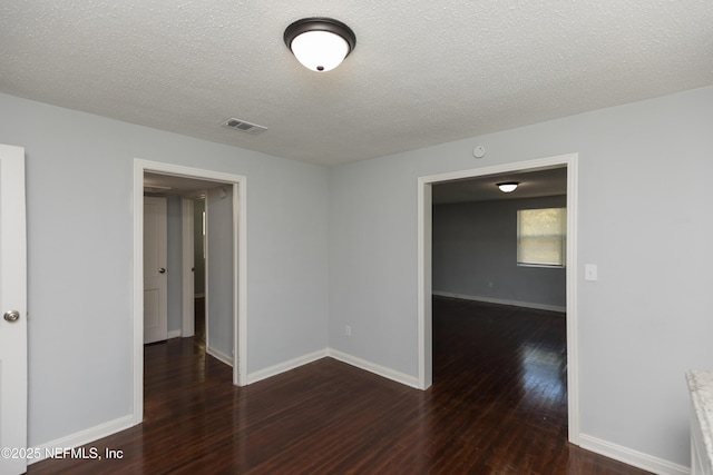 unfurnished room featuring dark hardwood / wood-style floors and a textured ceiling