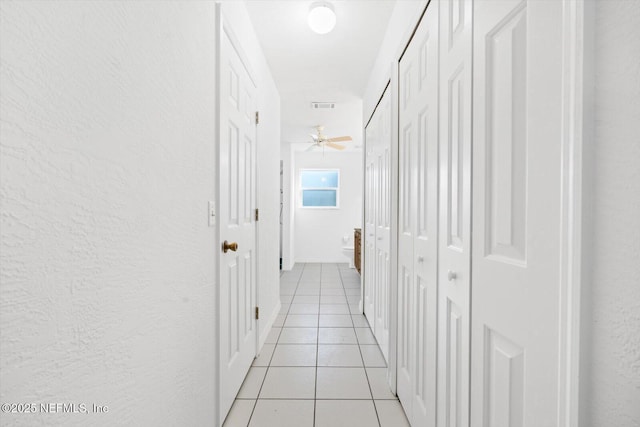 hall with light tile patterned floors