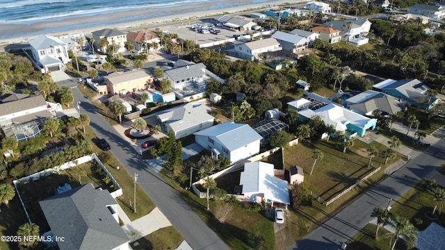 drone / aerial view featuring a water view and a view of the beach