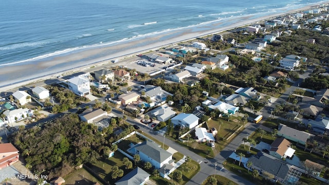 birds eye view of property featuring a water view and a beach view