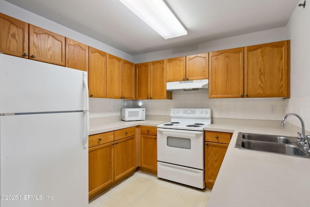 kitchen featuring sink, white appliances, and backsplash