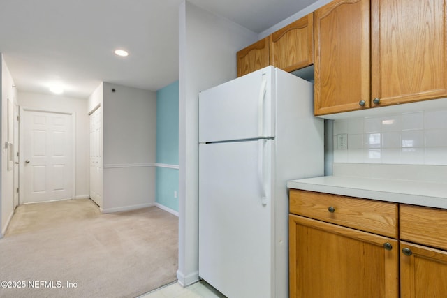 kitchen featuring white refrigerator, light carpet, and decorative backsplash