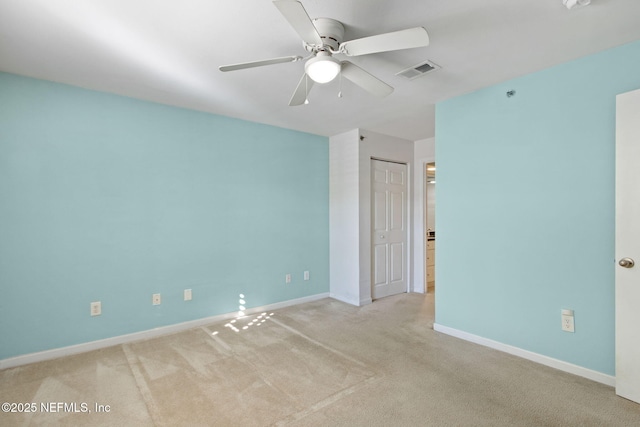 empty room featuring ceiling fan and light carpet