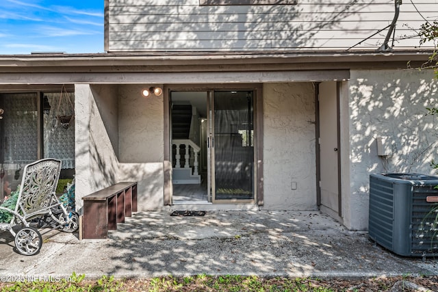 entrance to property with a patio area and central air condition unit