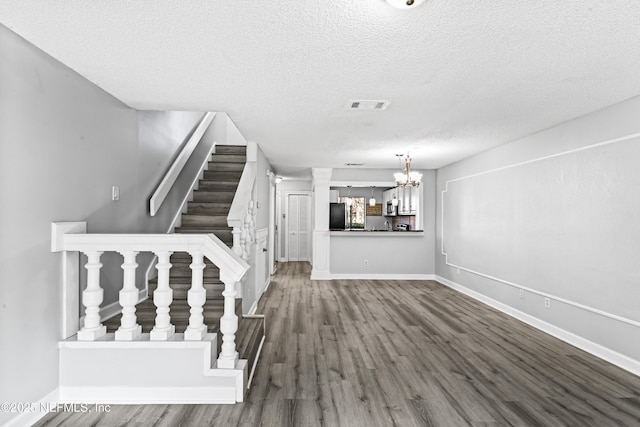 interior space with an inviting chandelier, wood-type flooring, and a textured ceiling