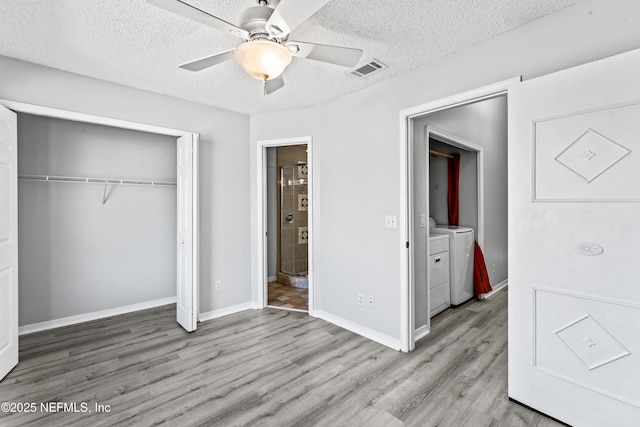 unfurnished bedroom with washer and clothes dryer, ceiling fan, light hardwood / wood-style floors, a textured ceiling, and a closet