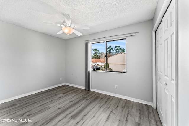 unfurnished bedroom featuring ceiling fan, light hardwood / wood-style flooring, a textured ceiling, and a closet