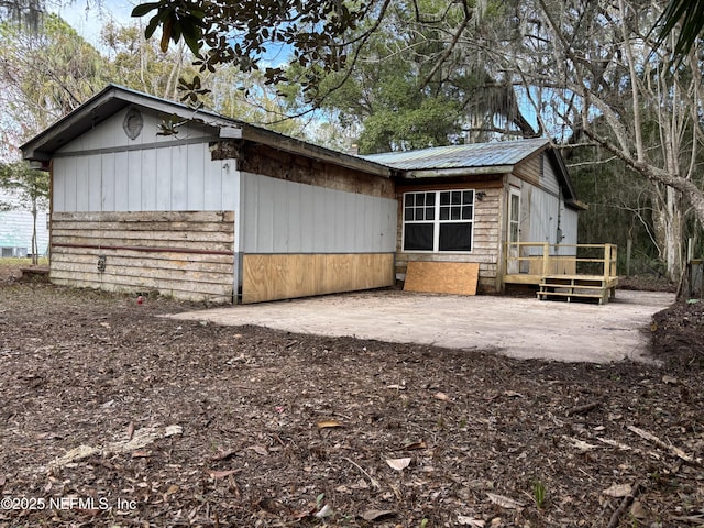 view of property exterior featuring a patio and a deck