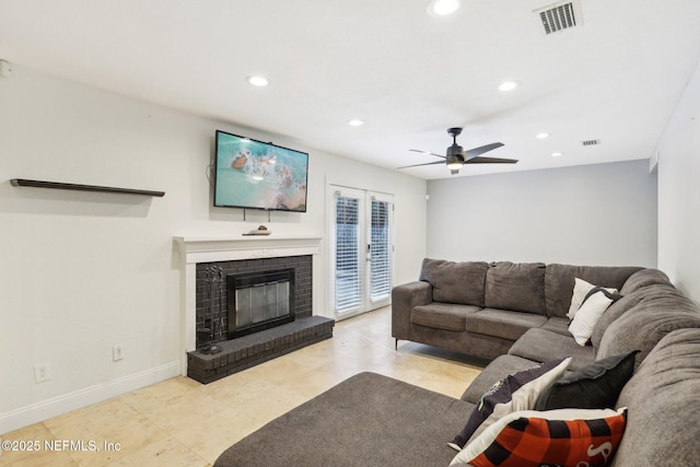 living room featuring a brick fireplace and ceiling fan