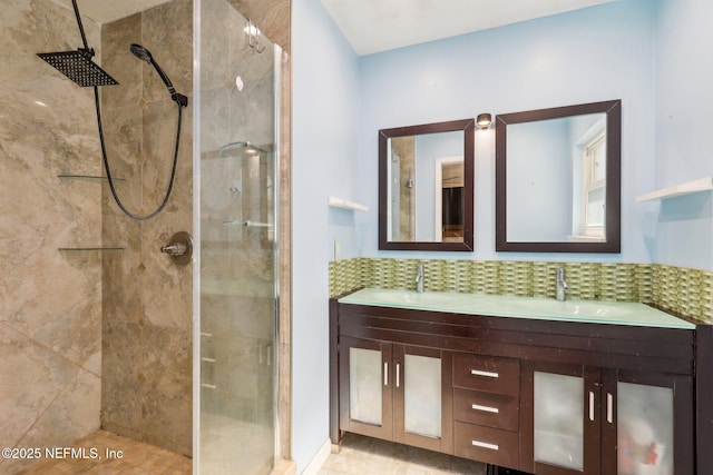 bathroom featuring vanity, decorative backsplash, and tiled shower