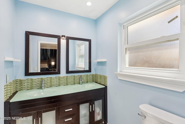 bathroom featuring tasteful backsplash, vanity, and toilet