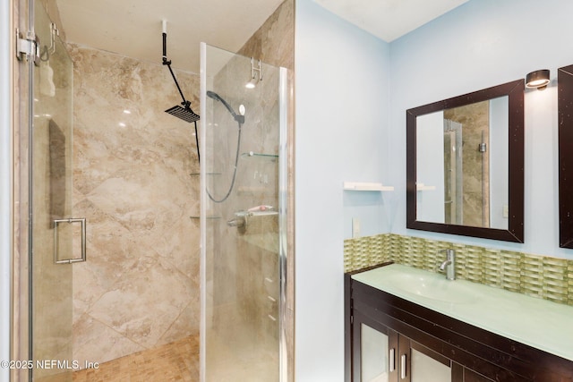 bathroom with vanity, a shower with door, and backsplash