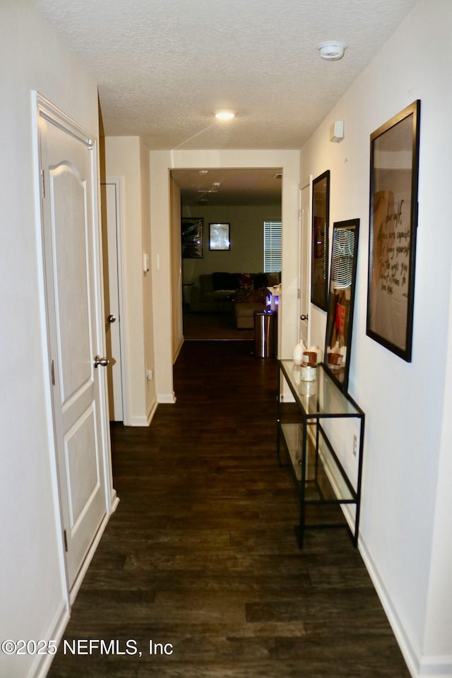 corridor featuring dark hardwood / wood-style floors and a textured ceiling