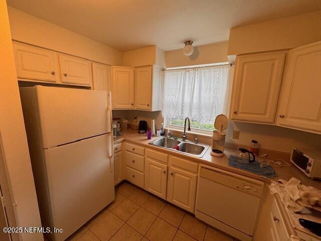 kitchen featuring light tile patterned flooring, white appliances, sink, and white cabinets