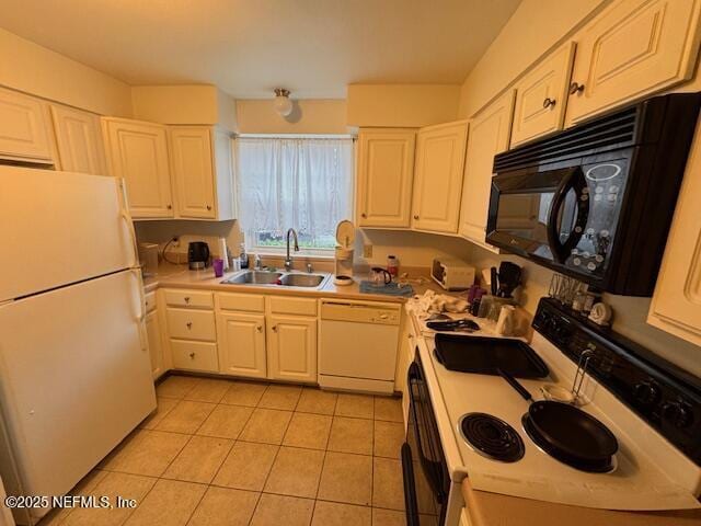 kitchen with white cabinetry, sink, white appliances, and light tile patterned floors