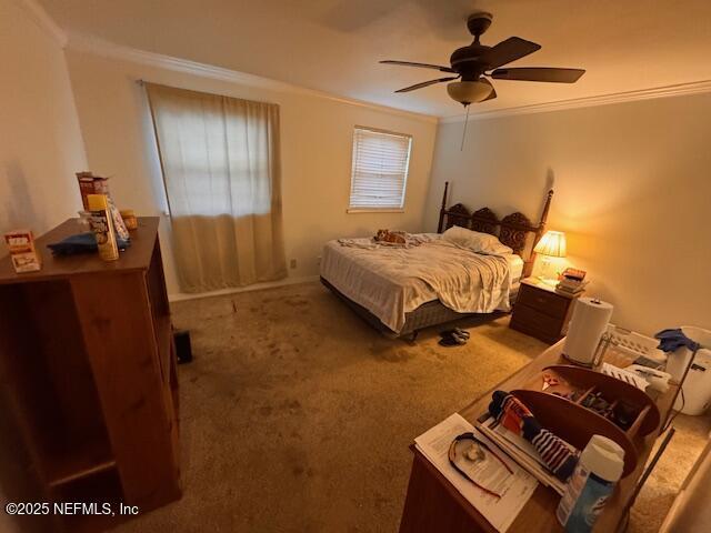 carpeted bedroom with ceiling fan and ornamental molding