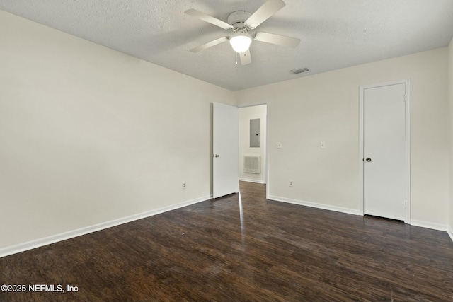 unfurnished bedroom with ceiling fan, electric panel, a textured ceiling, and dark hardwood / wood-style floors