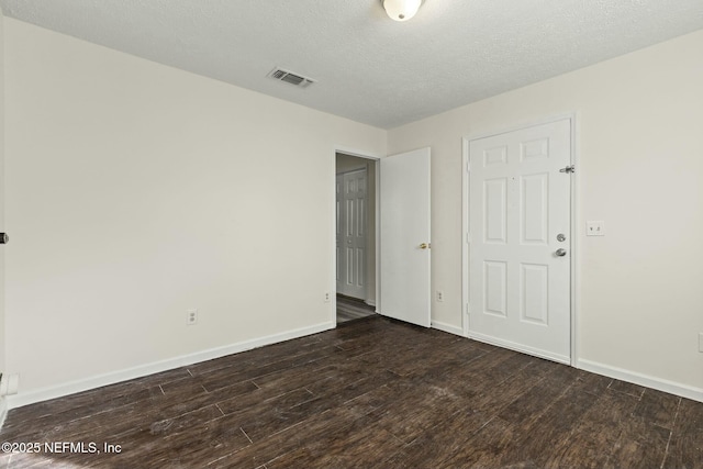 unfurnished bedroom with dark hardwood / wood-style flooring and a textured ceiling