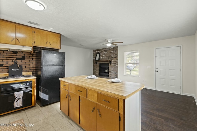 kitchen with light hardwood / wood-style floors, ceiling fan, black appliances, and a textured ceiling