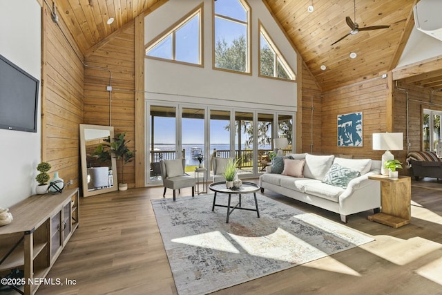 living room featuring a ceiling fan, wood ceiling, wooden walls, and wood finished floors