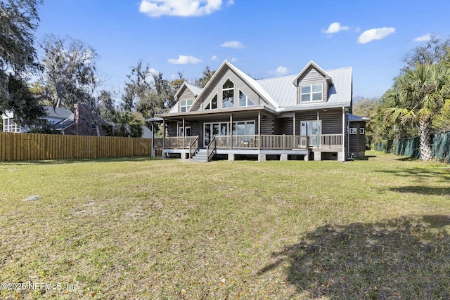 view of front of property with fence, metal roof, and a front yard