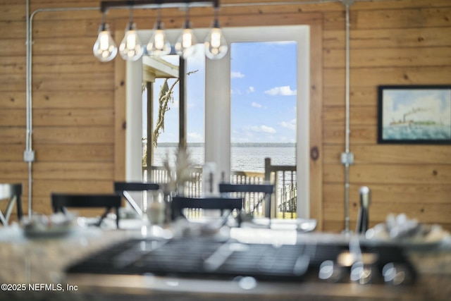 dining area featuring wood walls and a water view