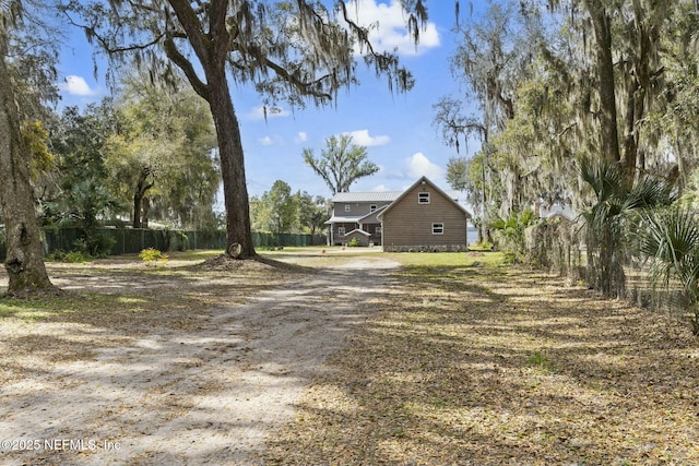 view of yard with driveway and fence