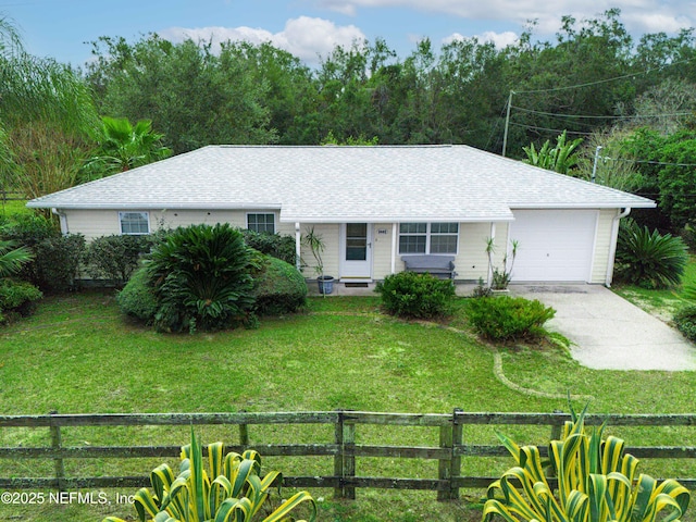 ranch-style house with a front yard, driveway, a shingled roof, a garage, and fence private yard