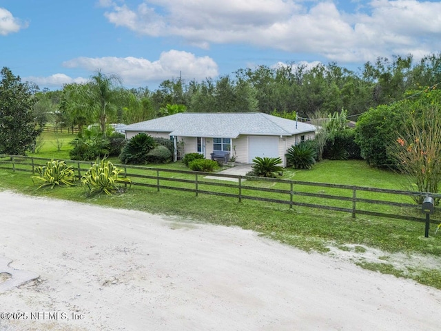 ranch-style house with a fenced front yard, a front yard, and a garage