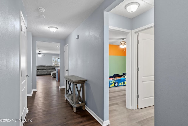 hallway featuring hardwood / wood-style floors and a textured ceiling