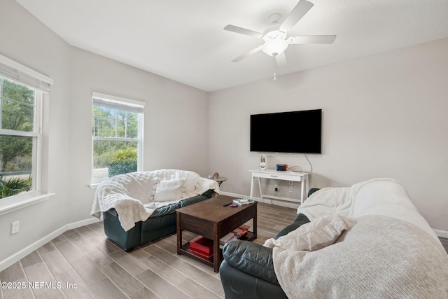 living room with ceiling fan and light hardwood / wood-style flooring