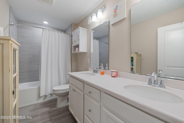 full bathroom with shower / bathtub combination with curtain, vanity, toilet, and a textured ceiling