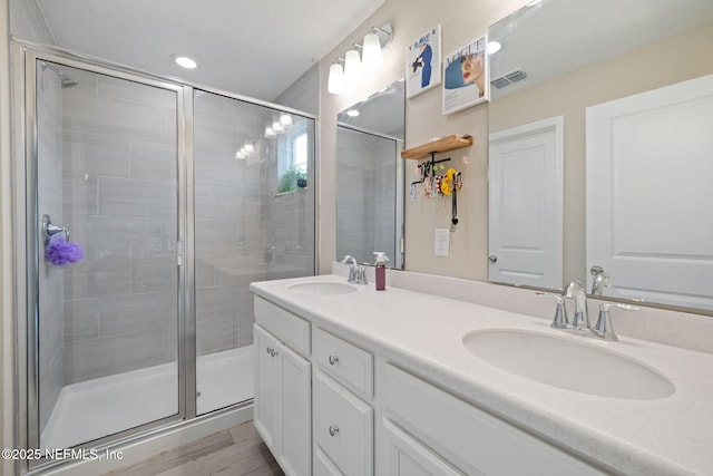 bathroom with vanity, an enclosed shower, and wood-type flooring