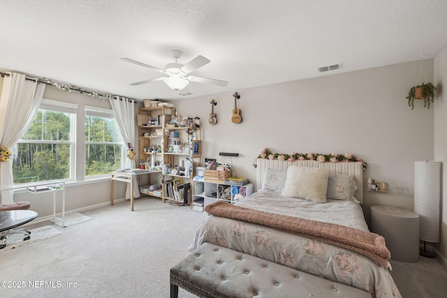 bedroom featuring ceiling fan, a textured ceiling, and carpet