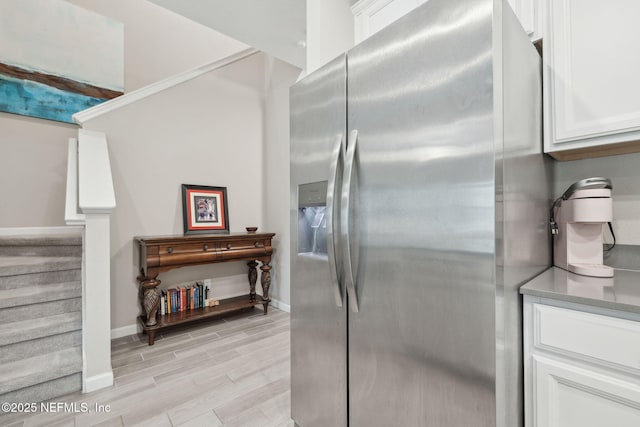 kitchen featuring white cabinetry and stainless steel fridge with ice dispenser