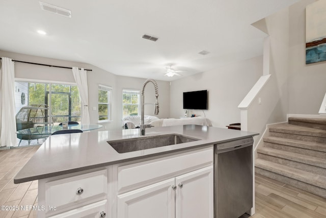 kitchen featuring sink, light wood-type flooring, dishwasher, an island with sink, and white cabinets