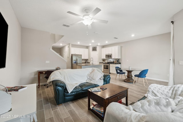 living room with ceiling fan and sink