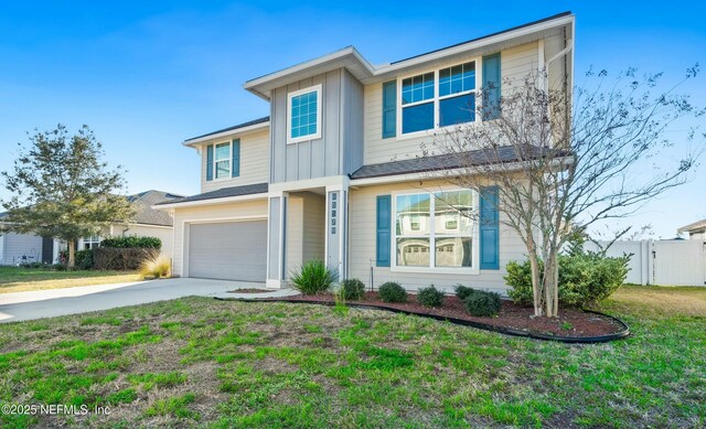 view of front of home with a garage, concrete driveway, board and batten siding, and a front yard