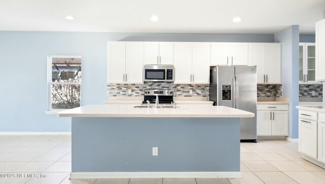 kitchen featuring a sink, white cabinetry, light countertops, appliances with stainless steel finishes, and an island with sink